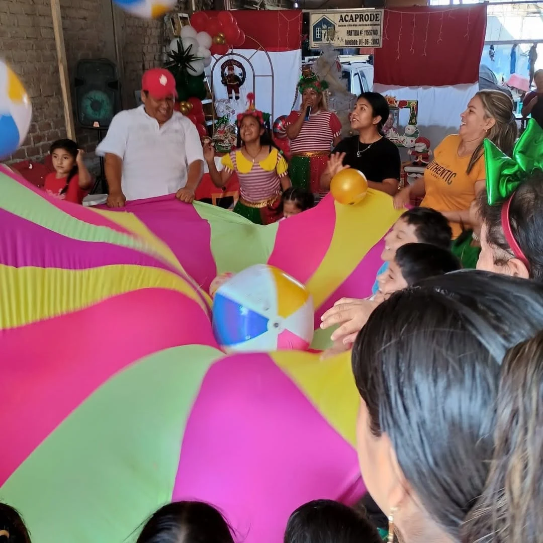 Niños y adultos compartiendo un juego con una tela de colores
