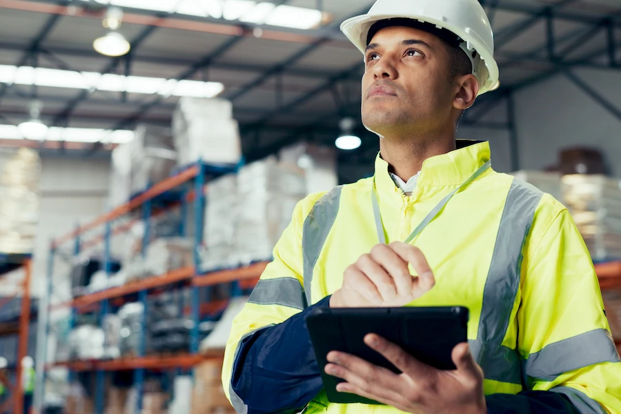 Especialista logístico revisando información en una tablet dentro de un almacén