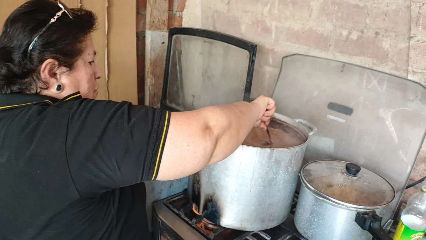 Participante preparando una chocolatada en una olla grande